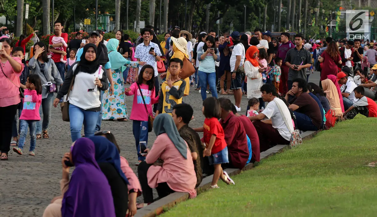 Pengunjung memadati kawasan Monumen Nasional (Monas), Jakarta, Rabu (27/6). Mengisi waktu libur Idul Fitri, kawasan Monas menjadi pilihan alternatif untuk berlibur bersama sanak keluarga. (Liputan6.com/Johan Tallo)