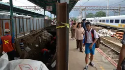 Calon penumpang melintas di samping proyek terowongan bawah tanah di Stasiun Kereta Api Manggarai, Jakarta, Kamis (12/3/2015). Pembangunan terowongan tersebut untuk memudahkan penumpang berpindah kereta antara peron. (Liputan6.com/Faizal Fanani)