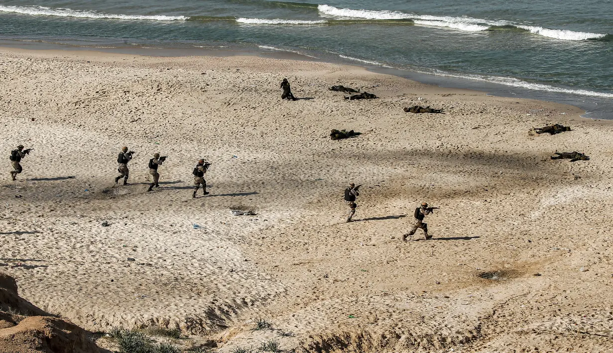 Pejuang bersenjata mengambil bagian dalam latihan militer oleh Hamas dan faksi bersenjata Palestina lainnya di pantai di Kota Gaza (29/12/2020). (AFP/Mohammed Abed)