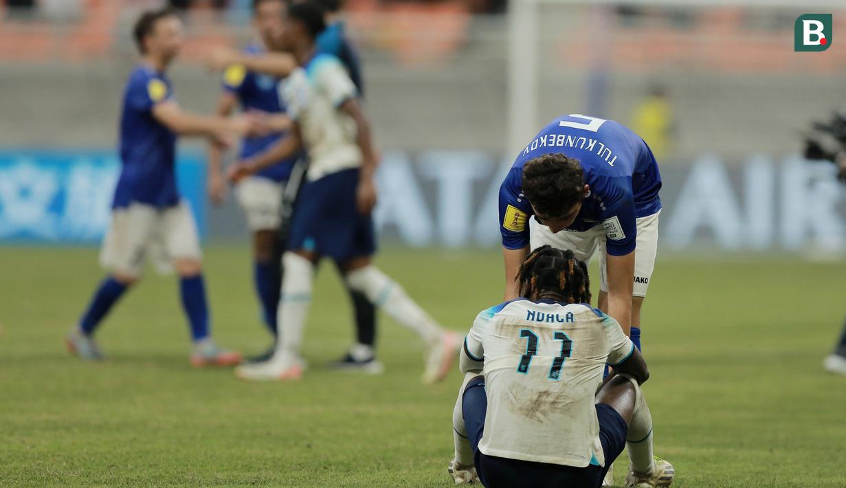 Pemain Timnas Uzbekistan U-17, Azizbek Tulkunbekov (kanan atas), memberikan semangat kepada pemain Inggris U-17, Joel Ndala, setelah pertandingan babak 16 besar Piala Dunia U-17 2023 yang berlangsung di Jakarta International Stadium, Rabu (22/11/2023) sore WIB. (Bola.com/M Iqbal Ichsan)