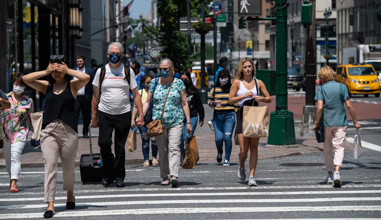Orang-orang berjalan menyusuri 5th Avenue pada hari yang hangat di New York City (7/6/2021). Cuaca yang hangat di New York dimanfaatkan warga untuk membaca buku hingga berjalan-jalan. (AFP/Angela Weiss)
