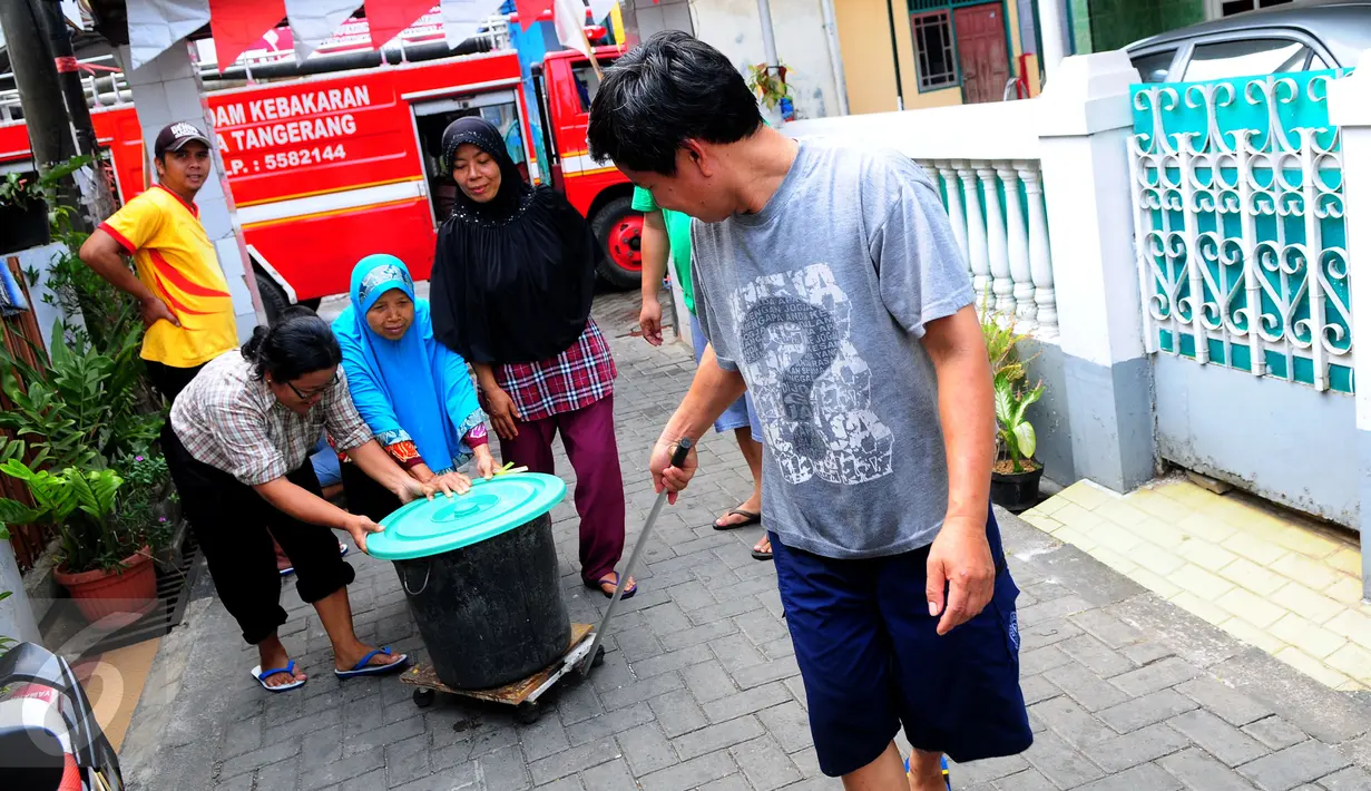 Warga bergotong royong mendorong ember saat pembagian bantuan air bersih di Jalan Kakap Raya, Tanggerang, Senin (17/8/2015). Dalam beberapa hari terakhir, warga Tangerang dan sekitarnya kesulitan mendapatkan air bersih. (Liputan6.com/Faizal R Syam)
