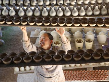 Seorang perajin bekerja di bengkel pembuatan tembikar di Desa Wanyao, sebuah desa di Mazhan yang berada di Tengchong, Provinsi Yunnan, China, 18 November 2020. Wanyao merupakan sebuah desa yang memiliki spesialiasi dalam pembuatan tembikar. (Xinhua/Liang Zhiqiang)