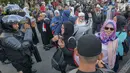 Sejumlah massa yang tergabung dalam Gerakan Pribumi Bersatu berbincang dengan Polisi dari kesatuan Brimob saat gelar doa bersama di depan kantor Bawaslu, Jakarta, Jumat (24/5/2019). Mereka datang untuk mendoakan para demonstran yang meninggal saat aksi 21-22 Mei. (Liputan6.com/Herman Zakharia)