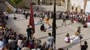 Pria berkostum setan melompati bayi-bayi yang terlentang di atas matras di sebuah jalan selama festival El Colacho di desa Castrillo de Murcia, bagian utara Spanyol, 23 Juni 2019. Adapun bayi yang dijajarkan dan dilompati 'El Colacho' telah mendapat izin dari orangtua sang bayi. (CESAR MANSO/AFP)
