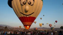 Salah satu peserta yang bersiap menerbangkan balon udaranya saat Festival balon udara di Cajititlan, Meksiko, Minggu (7/5).  Festival balon udara ini menjadi tontonan menarik bagi warga sekitar dan wisatawan. (AFP PHOTO / Hector Guerrero)