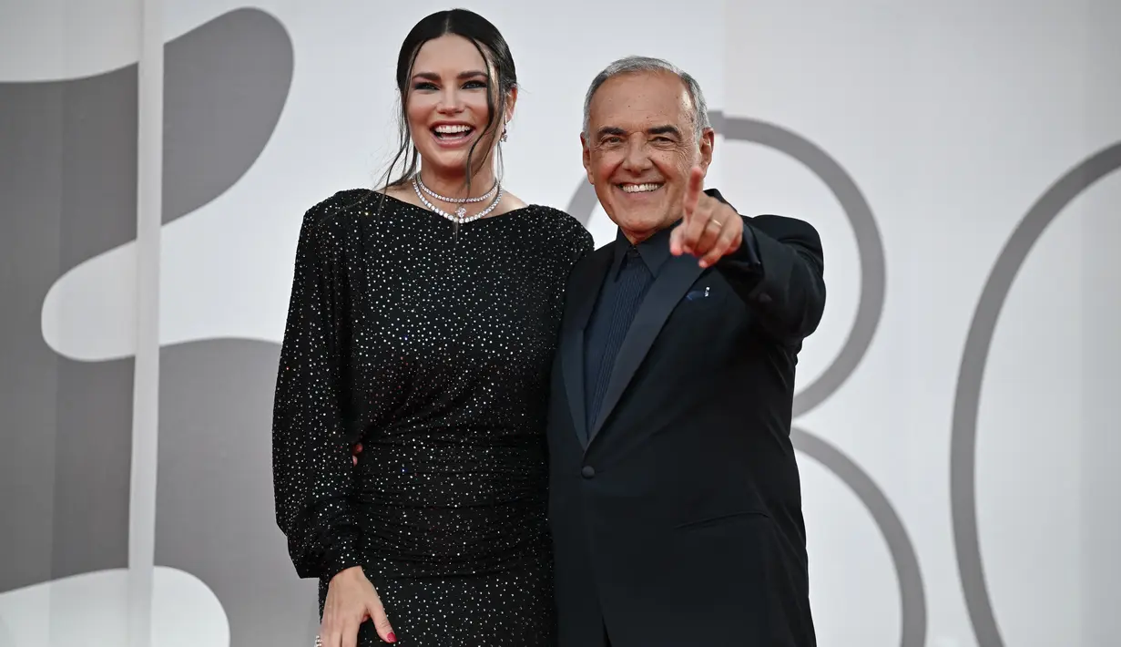 Dia mengenakan riasan mata smokey-eyes gelap, yang mempercantik warna hijau pada matanya, dan memulas bibirnya dengan lipstik nude yang lembut. (Photo by Tiziana FABI / AFP)