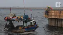 Pekerja menyelesaikan proyek tanggul pengaman pantai Kampung Nelayan Cilincing, Jakarta, Jumat (10/11/2023). (merdeka.com/Imam Buhori)