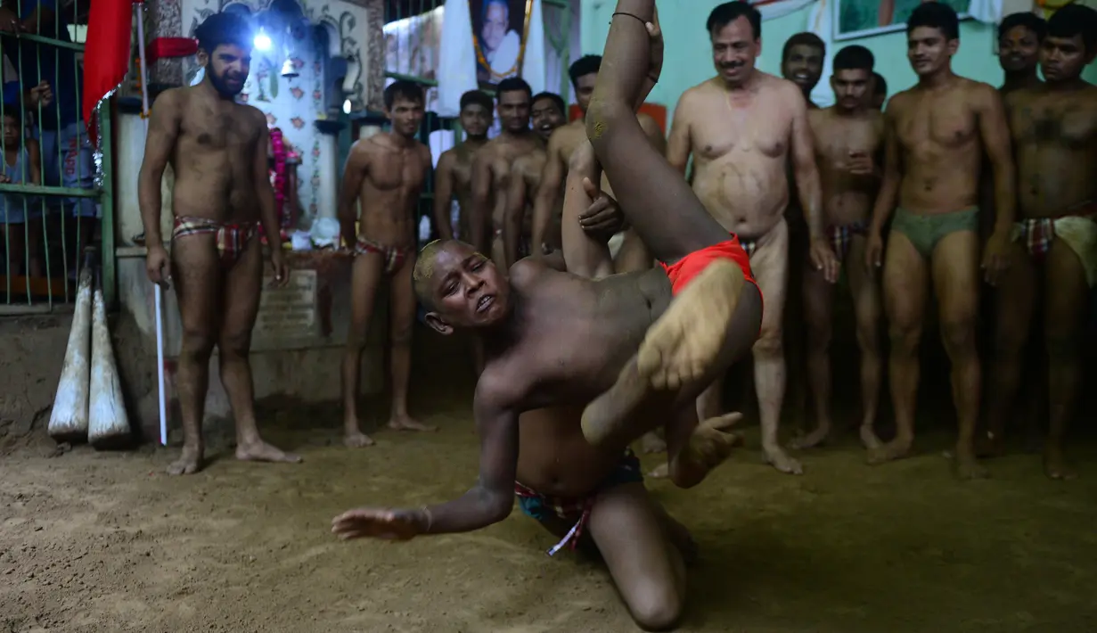 Dua remaja bertarung dalam gulat tradisional di klub gulat Loknath Vyayamsala untuk menandai festival Nag Panchami, di Allahabad (15/8). Di beberapa kota utara Festival Hindu Nag Panchami mengadakan gulat tradisional. (AFP Photo/Sanjay Kanojia)