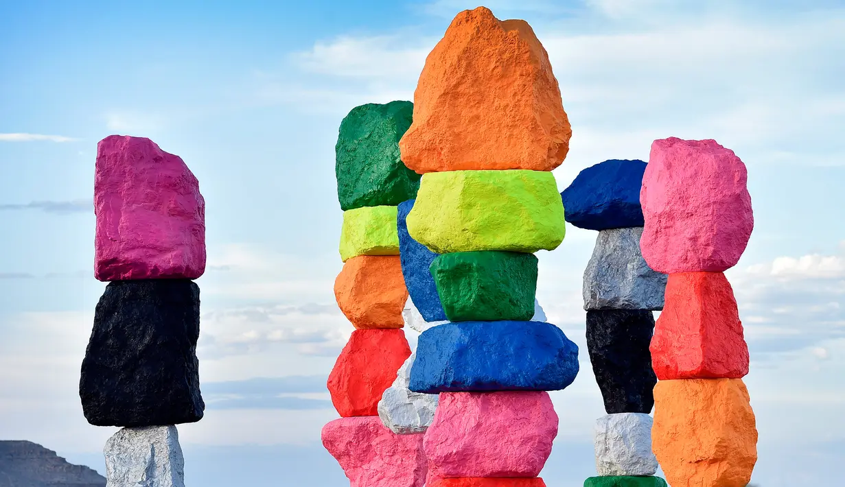 Pengunjung menikmati instalasi seni yang berjudul ' Seven Magic Mountains' di dekat Jean , Nevada, 14 Mei 2016. Proses pembuatan tujuh menara mirip mainan anak ini selam lima tahun. (David Becker / AFP)