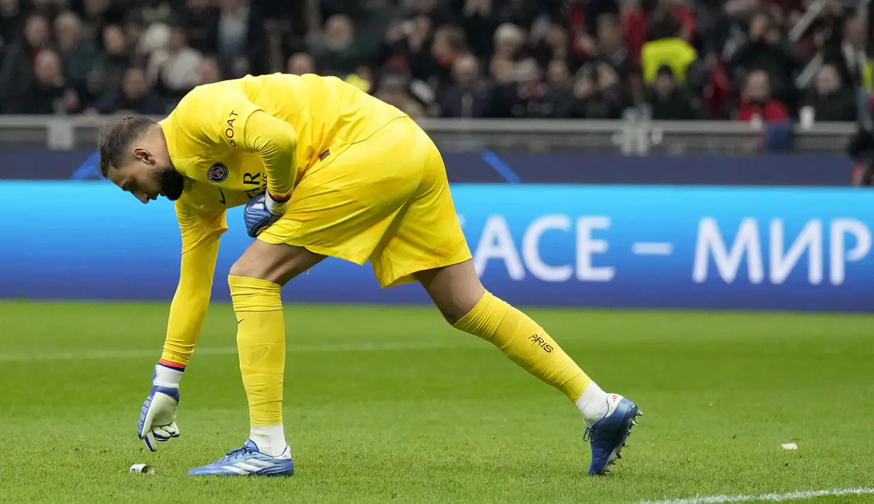 Penjaga gawang PSG, Gianluigi Donnarumma, mengambil uang palsu bergambar dirinya untuk disingkirikan dalam laga matchday 4 Liga Champions 2023/2024 yang berlangsung di San Siro, Milan, Rabu (8/11/2023) dini hari WIB. Uang palsu tersebut dilempar oleh Ultras Milan sebagai bentuk kekecewaan kepada Donnarumma yang pindah ke PSG karena tawaran yang menggiurkan. (AP Photo/Antonio Calanni)