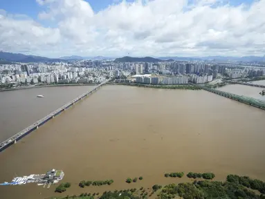 Sungai Han, yang meluap karena banjir, mengalir di bawah jembatan di Seoul, Korea Selatan (6/9/2022). Topan paling kuat yang melanda Korea Selatan selama bertahun-tahun menerjang wilayah selatannya Selasa, membuang satu meter (3 kaki) air hujan, menghancurkan jalan dan meruntuhkan kabel listrik, menyebabkan 66.000 rumah tanpa listrik saat ribuan orang mengungsi ke tempat yang lebih aman. (AP Photo/Ahn Young-joon)