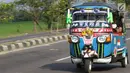 Sebuah bajaj digunakan oleh pemudik melintasi Jalur Pantura Cirebon, Jawa Barat, Kamis, (29/6). Memasuki H+4 Lebaran jalur Pantura Cirebon mengarah ke Jakarta mulai dipadati pemudik pengguna kendaraan bermotor roda dua (Liputan6.com/Helmi Afandi)