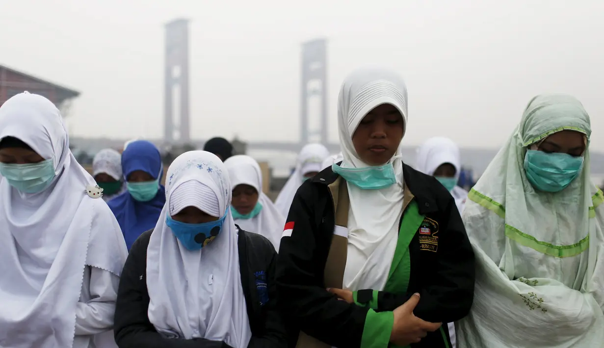 Sejumlah warga melakukan Salat Minta Hujan dekat Sungai Musi di Palembang, Minggu (20/9/2015). Mereka berharap Tuhan segera menurunkan hujan dan menghilangkan kabut asap yang melanda Sumatra dan Kalimantan. (Reuters/Beawiharta)