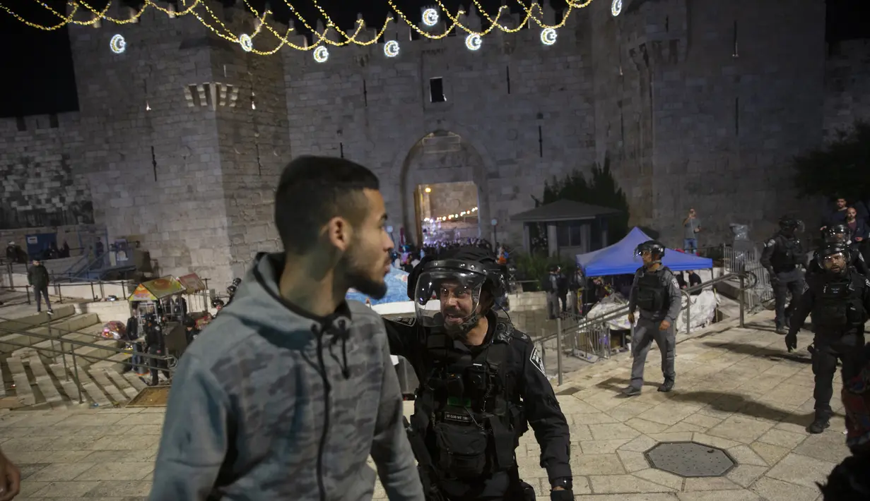 Seorang polisi Israel berteriak kepada seorang pria Palestina untuk meninggalkan Gerbang Damaskus ke Kota Tua Yerusalem setelah bentrokan di kompleks Masjid Al-Aqsa (7/6/2021). (AP Photo/Mahmoud Illean)