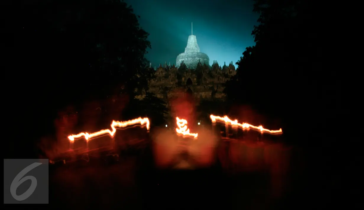 Wisatawan menyalakan lilin dengan latar belakang Candi Borobudur saat dilaksanakan program Earth Hour atau peringatan Hari Bumi oleh WWF, UNESCO dan Balai Konservasi Borobudur, Magelang, Jawa Tengah, Sabtu (19/3) malam. (Foto: Boy Harjanto)