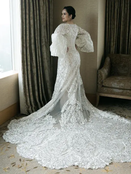 Jubah pengantin bergaya bodice dengan bustier yang bisa dilepas ini memiliki ekor yang menjuntai indah. [@monicaivena]