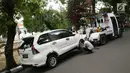 Petugas Dinas Perhubungan mengaitkan kendaraan pada mobil derek di kawasan Pasar Baru, Jakarta, Kamis (14/12). Meskipun sering ditertibkan, namun masih banyak pengendara yang nekat parkir sembarangan. (Liputan6.com/Immanuel Antonius)