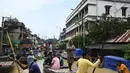 Warga menaiki perahu di atas jalan yang terendam banjir menyusul hujan lebat di Ghatal, distrik Paschim Medinipur, sekitar 100 km dari Kolkata (2/8/2021). Banjir parah akibat hujan lebat membuat jalanan di Ghatal berubah bak sungai. (AFP/Dibyangshu Sarkar)