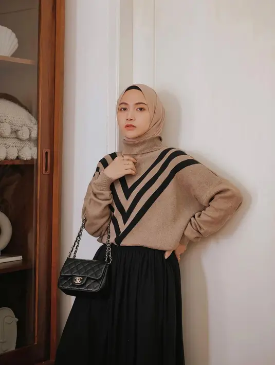 <p>Sweater knit berwarna coklat dengan detail motif segitiga berwarna hitam sangat cantik dikolaborasikan dengan rok berwarna hitam.&nbsp;(instagram/nisacookie)</p>
