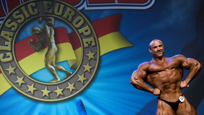 Binaragawan dari Belarusia, Ilya Lukovets memamerkan otot di depan juri pada kontes Arnold Classic Europe 2019 di Barcelona, Sabtu (21/9/2019). Arnold Classic Europe merupakan kompetisi body builder yang akan berlangsung dari 20 hingga 22 September. (Photo by LLUIS GENE / AFP)