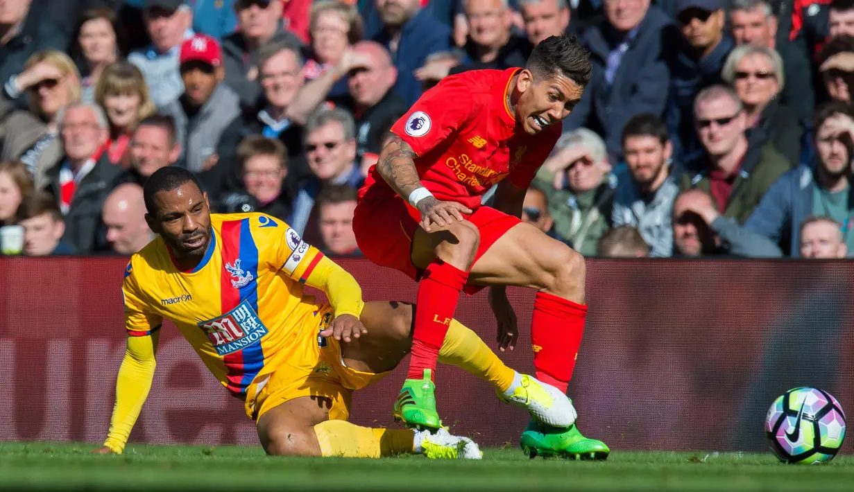 Crystal Palace, Jason Puncheon (kiri) terjatuh saat berduel dengan pemain Liverpool, Roberto Firmino (kanan) pada lanjutan Premier League di Anfield Stadium, Liverpool, (23/4/2017). Liverpool kalah 1-2. (EPA/Peter Powell)