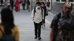 Seorang pria berjalan mengenakan masker pelindung untuk menghindari polusi udara buruk di Jakarta, Rabu (17/7/2019). Dinkes DKI menyarankan masyarakat untuk menggunakan masker saat beraktivitas untuk mencegah dampak polusi udara pada tubuh. (Liputan6.com/Faizal Fanani)