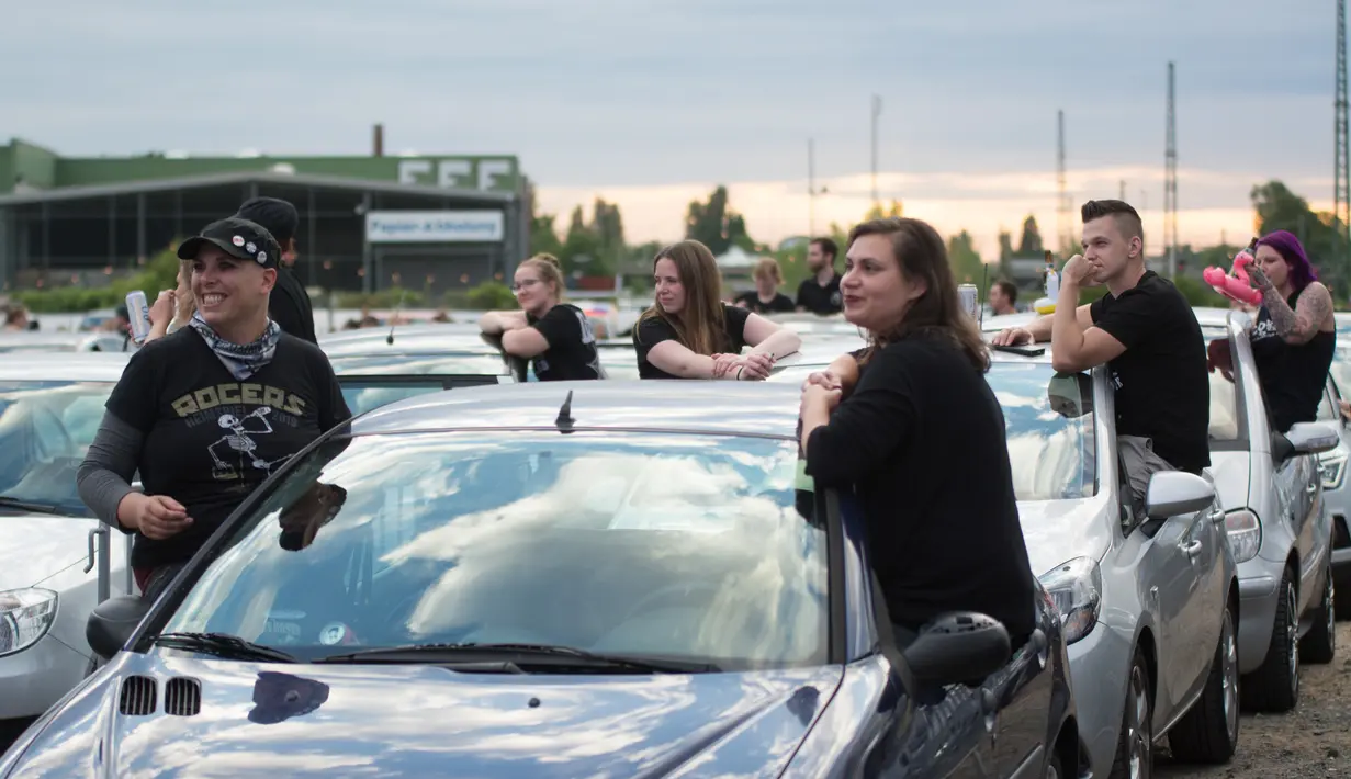 Orang-orang menonton konser drive-in dari kendaraan mereka di Bonn, Jerman, Sabtu (13/6/2020). Konser tersebut digelar dengan langkah-langkah ketat bagi para penikmat musik sambil menjaga jarak sosial. (Xinhua/Tang Ying)