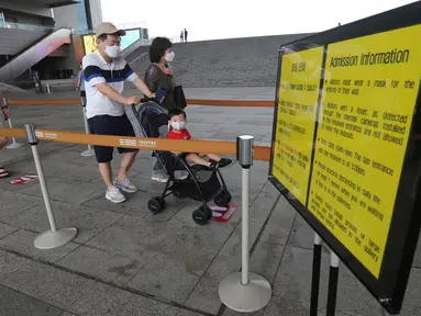 Pengunjung yang mengenakan masker memasuki ruang pameran di Museum Nasional Korea di Seoul, Korea Selatan, Rabu (22/7/2020). Museum ini dibuka kembali pada Rabu (22/7) setelah ditutup selama dua bulan akibat pandemi corona Covid-19. (AP Photo/Ahn Young-joon)