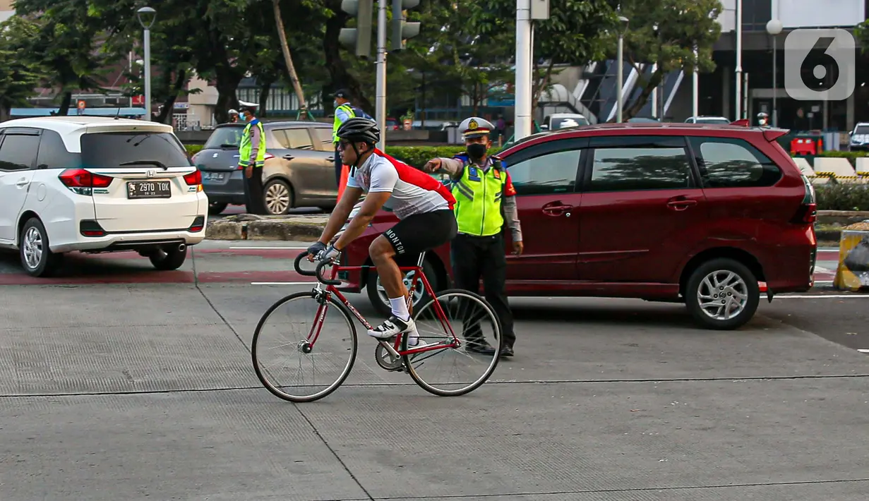 Polisi menghalau pesepeda yang berada di luar jalur di kawasan Sudirman-Thamrin, Jakarta Pusat, Rabu (2/6/2021). Sepeda road bike diperbolehkan untuk melintas di Jalan Sudirman-Thamrin pada hari kerja Senin-Jumat, namun dibatasi dari pukul 05.00-06.30 WIB. (Liputan6.com/Faizal Fanani)