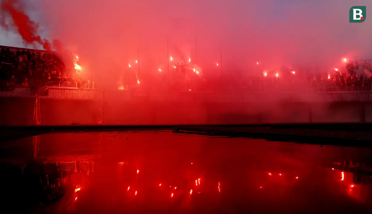 Suporter Persita Tangerang menyalakan flare saat merayakan keberhasilan Pendekar Cisadane selamat dari degradasi Liga 1 2024 di Stadion Indomilk Arena, Tangerang, Selasa (30/4/2024). (Bola.com/M Iqbal Ichsan)