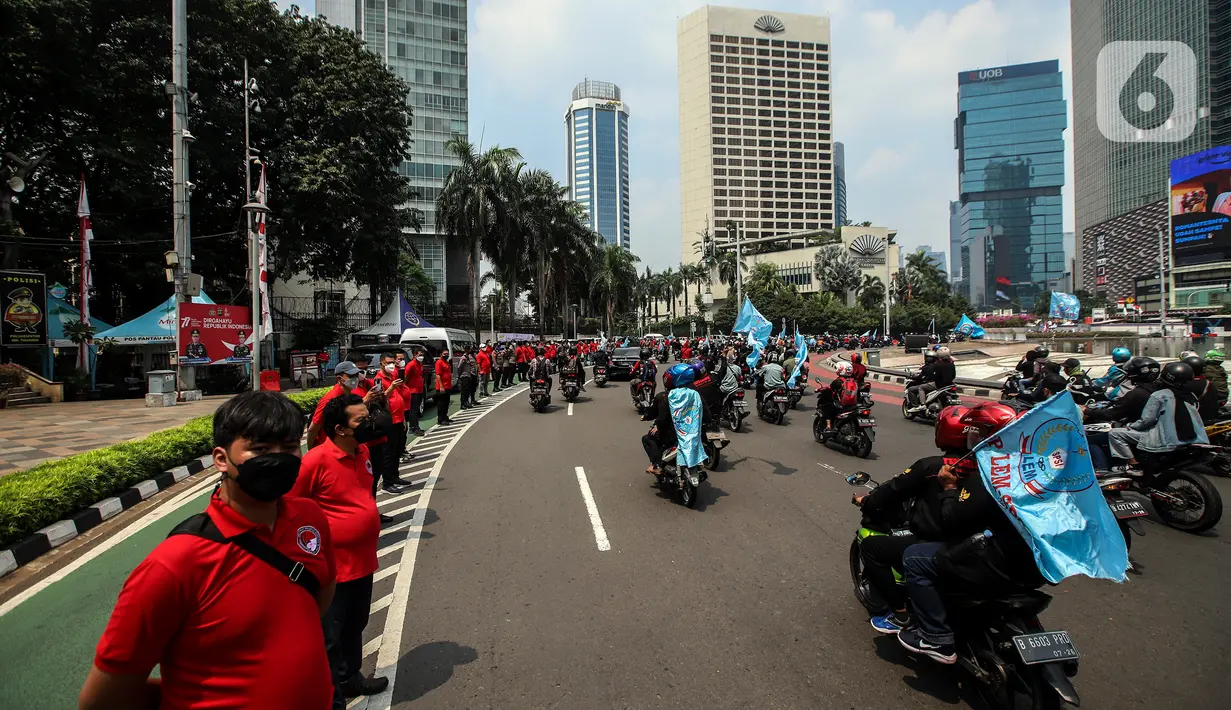 Buruh melakukan konvoi menggunakan sepeda motor di Bundaran Hotel Indonesia untuk mengikuti unjuk rasa di depan Gedung DPR, Jakarta, Rabu (10/8/2022). Dalam aksi tersebut mereka menuntut agar pemerintah menghapus Omnibus Law. (Liputan6.com/Johan Tallo)
