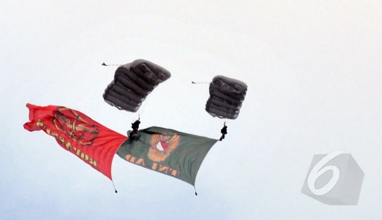 Prajurit  membentangkan bendera Kopassus dan TNI AD  saat aksi terjun payung 18 lapis dalam perayaan HUT ke-63 satuan elite baret merah tersebut di Cijantung, Jakarta, Rabu (29/4/2015). (Liputan6.com/Herman Zakharia)