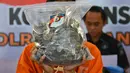 Tersangka memperlihatkan barang bukti sisik satwa trenggiling di Mapolresta Banda Aceh, Aceh, Rabu (21/8/2019). Polisi membekuk tiga orang secara terpisah, yang diduga merupakan eksekutor dan penjual hewan dilindungi tersebut dengan harga Rp 3 juta perkilogramnya. (CHAIDEER MAHYUDDIN/AFP)