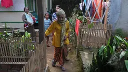 Nenek Anami tampak menyusuri jalan setapak di sekitar rumahnya di Purwakarta, Jabar, Minggu (17/5). Nenek yang diduga berusia 140 tahun ini akan mengikuti sayembara orang tertua di dunia yang digelar miliarder Rusia. (Liputan6.com/Herman Zakharia)