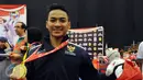 Ahmad Zigi Zaresta memamerkan medali yang diperoleh di nomor Junior Kata Male di WKF World Junior, Cadet and U-21 Championship 2015 di ICE Serpong, Banten, Kamis (12/11/2015). Zigi menyumbang emas pertama bagi Indonesia. (Liputan6.com/Helmi Fithriansyah)
