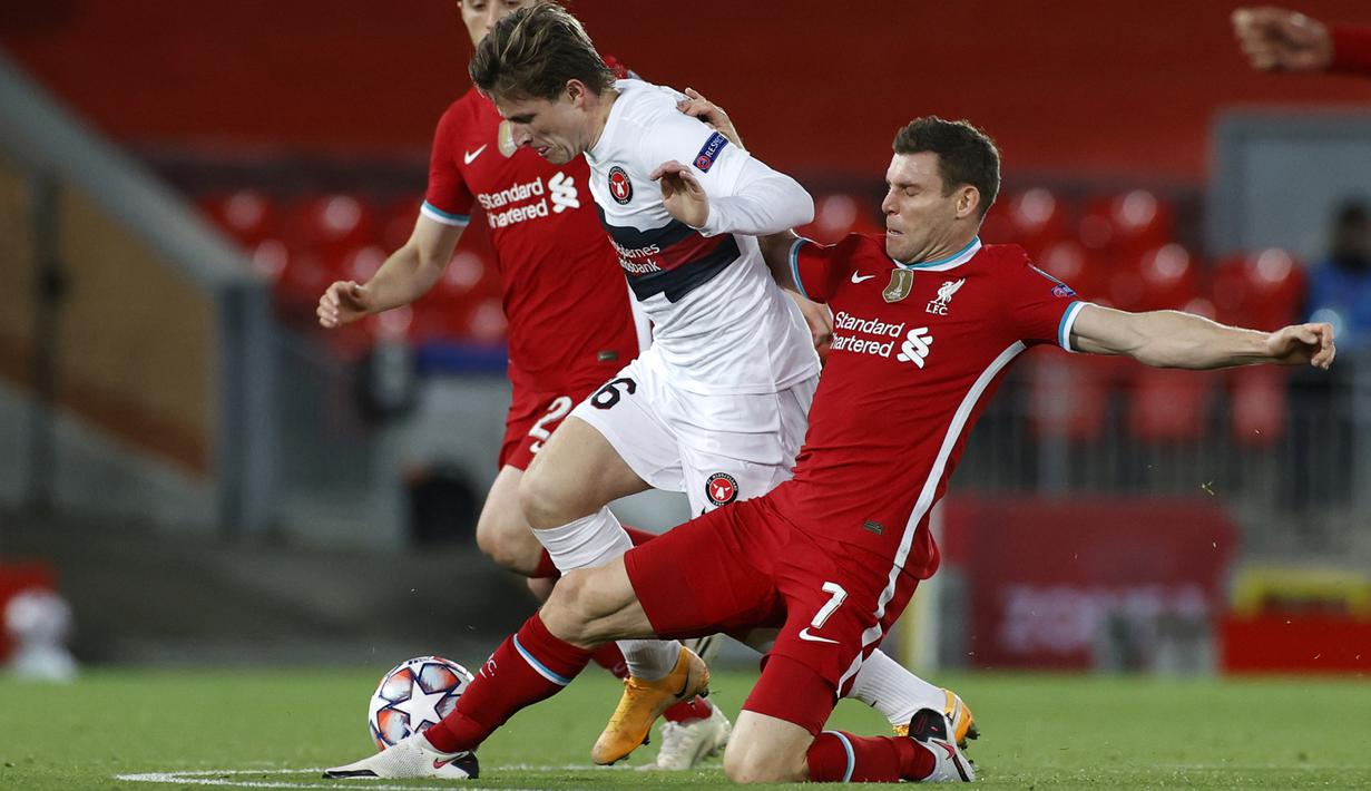 Gelandang Liverpool, James Milner, berebut bola dengan gelandang Midtjylland, Anders Dreyer, pada laga Liga Champions 2020/2021 di Stadion Anfield, Rabu (28/10/2020) dini hari WIB. Liverpool menang 2-0 atas Midtjylland. (AFP/Phil Noble/pool)