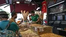 Pedagang melayani pembeli di Spice Bazaar yang bersejarah di distrik Eminonu di Istanbul, Turki (13/7/2019). Tempat tersebut menjadi spesial karena berbagai macam rempah-rempah pedas khas Turki dijual disitu. (AFP Photo/Ozam Kose)