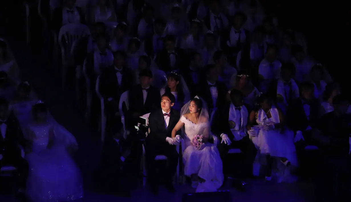 Pasangan pengantin menyaksikan ke arah layar saat menghadiri upacara pernikahan massal di Cheong Shim Peace World Center, Gapyeong, Korea Selatan, Senin (27/8). (AP Photo/Ahn Young-joon)