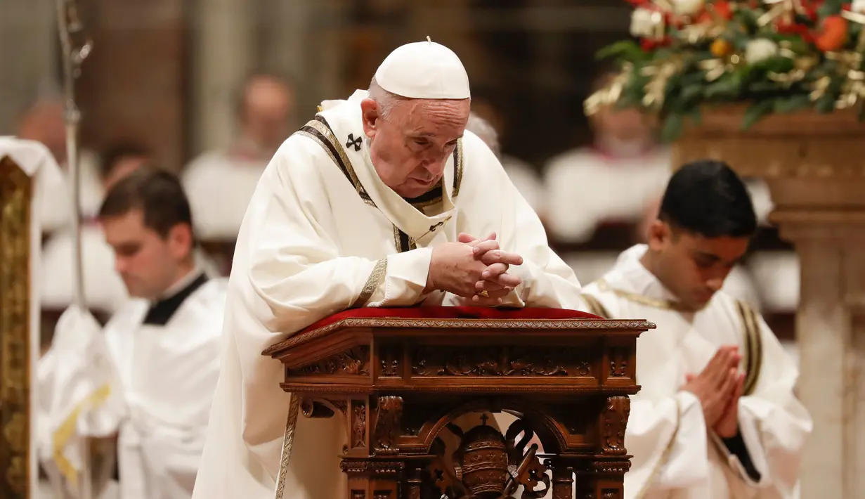 Paus Fransiskus berdoa ketika memimpin misa Malam Natal di Basilika Santo Petrus, Vatikan, Selasa (24/12/2019). Paus Fransiskus memimpin Natal bagi 1,3 miliar umat Katolik dunia. (AP Photo/Alessandra Tarantino)