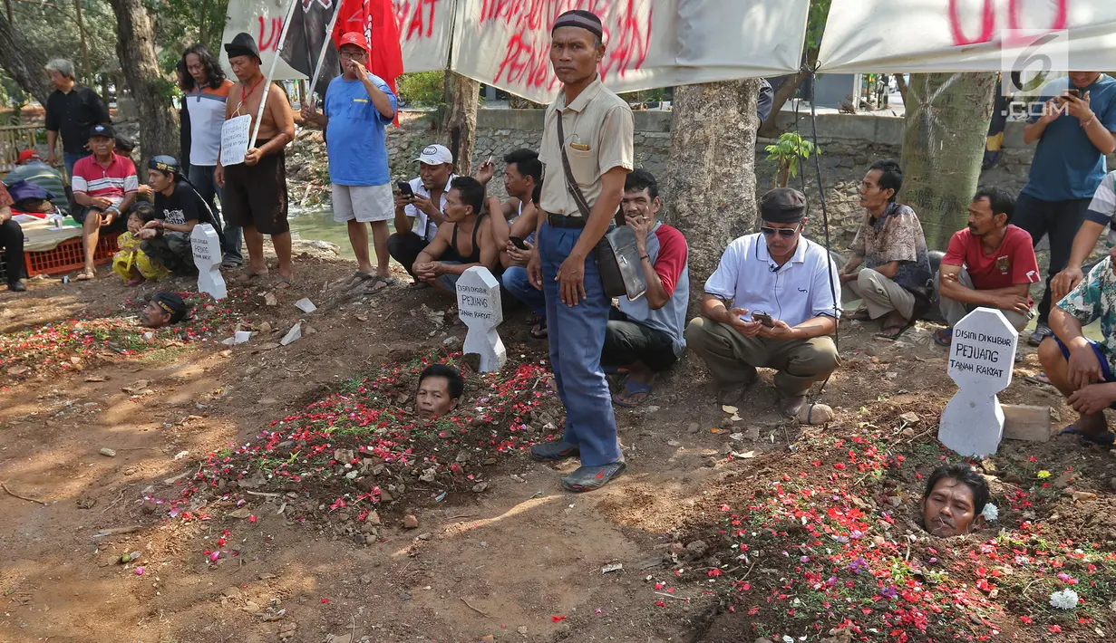 Warga yang tergabung dalam Aliansi Tanah Untuk Rakyat melakukan aksi kubur diri di Taman Kayu Mas, Pulogadung, Jakarta Timur, Jumat (23/8/2019). Mereka menuntut  BPN Jakarta Timur mempercepat proses pengukuran dan melawan mafia tanah. (Liputan6.com/Herman Zakharia)
