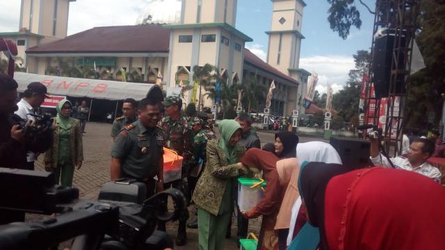 Menemani istri, Panglima Daerah Militer (Pangdam) III/Siliwangi, Mayor Jenderal TNI Nugroho Budi Wiryanto tengah memberikan bantuan kepada warga Garut, saat baksos Hari Juang Angkatan Darat di Alun-alun Garut