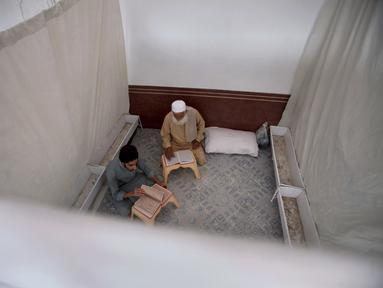 Umat Muslim membaca al-Quran saat melakukan ibadah itikaf di sebuah masjid, di Peshawar , Pakistan, 22 April 2022. Itikaf adalah adalah tinggal atau menetap di dalam masjid dengan niat beribadah untuk mendekatkan diri kepada Allah dan biasanya dilakukan sepuluh hari terakhir Ramadhan. (AP Photo/Muhammad Sajjad)