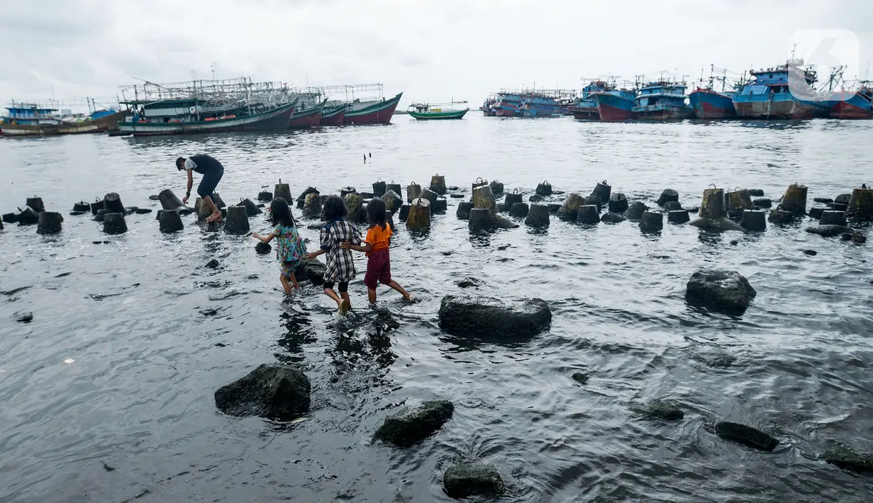 Anak-anak bermain di pesisir laut Jakarta, Kamis (9/1/2020). Pemprov DKI Jakarta melalui Dinas Sumber Daya Air (SDA) memetakan kawasan yang rawan diterjang banjir rob selama cuaca ekstrem melanda Jakarta pada 9 hingga 12 Januari 2020. (merdeka.com/Imam Buhori)