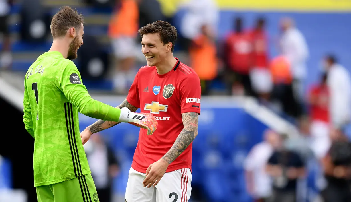 Kiper Manchester United, David de Gea berselebrasi dengan bek timnya, Victor Lindelof pada akhir partai pamungkas Liga Inggris menghadapi Leicester City di Stadion King Power, Minggu (26/7/2020). MU lolos ke Liga Champions musim depan usai mengalahkan Leicester City 2-0. (Michael Regan/Pool via AP)