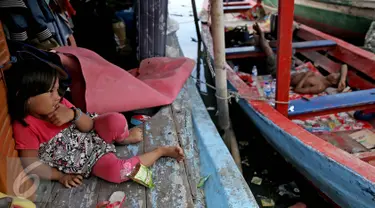 Seorang anak duduk di atas kapal pasca penggusuran permukiman Pasar Ikan, Jakarta, Selasa (13/4/2016). Warga Pasar Ikan mengaku belum mendapat rumah susun sewa yang telah dijanjikan oleh Pemprov DKI Jakarta. (Liputan6.com/Faizal Fanani)
