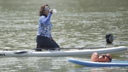 Menteri Kelautan dan Perikanan, Susi Pudjiastuti, melepas dahaga saat bermain paddle board di Danau Sunter, Jakarta, Minggu (25/2/2018). Kegiatan ini dilakukan dalam rangka Festival Danau Sunter. (Bola.com/Okie Prabhowo)