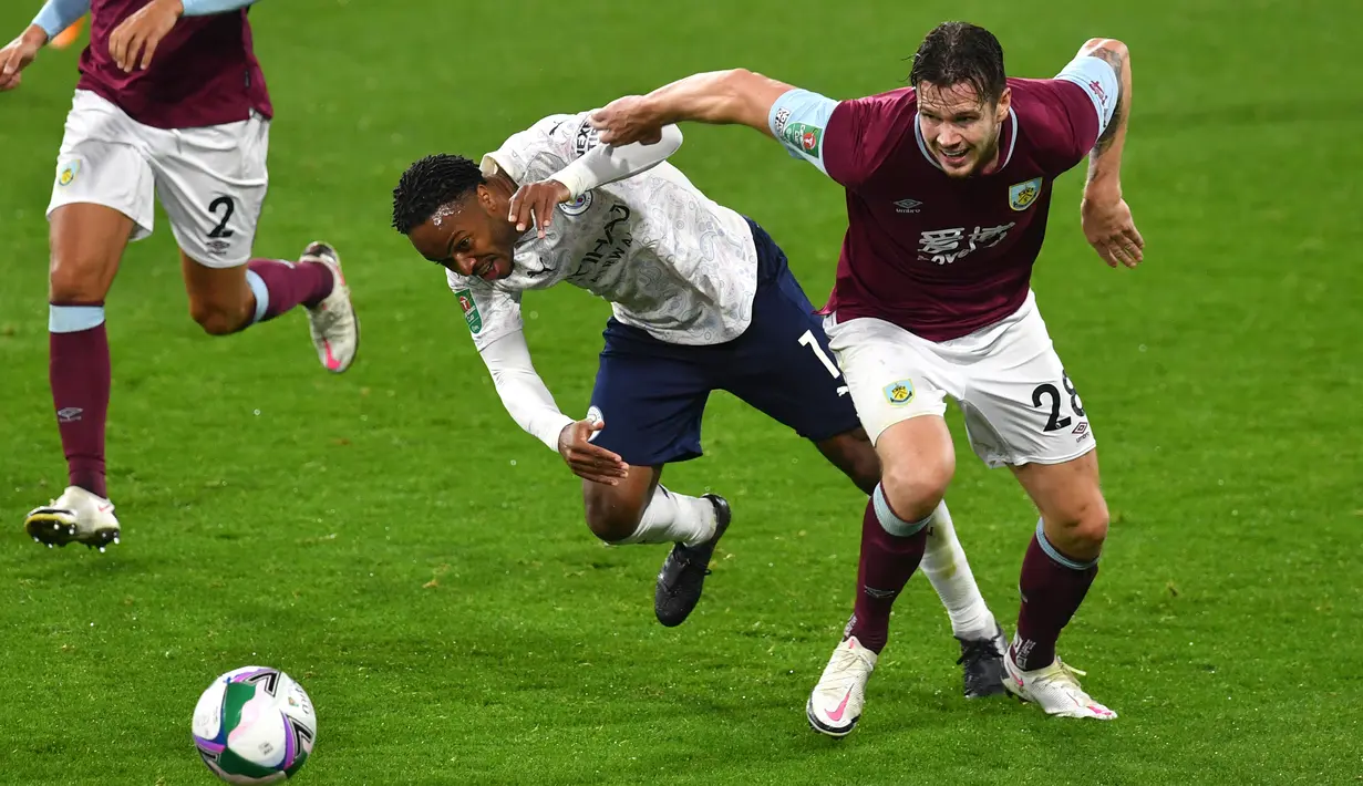 Penyerang Manchester City, Raheem Sterling berebut bola dengan pemain  Burnley, Kevin Long pada laga babak keempat Piala Liga Inggris di Turf Moor, Kamis (1/10/2020) dini hari WIB. Raheem Sterling mencetak dua gol saat Manchester City menang 3-0 atas Burnley. (Paul Ellis/Pool via AP)