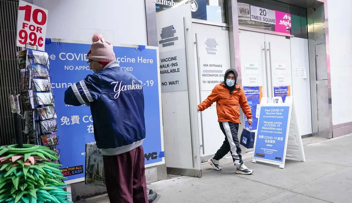 Seorang pria (kanan) meninggalkan pusat vaksin NYC di Times Square New York, Senin (6/12/2021). Wali Kota Bill de Blasio mengumumkan semua pengusaha swasta Kota New York harus mewajibkan pekerja mereka untuk divaksinasi COVID-19 mulai 27 Desember. (AP Photo/Mary Altaffer)