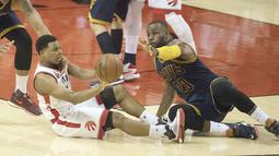 Pemain Raptors, Kyle Lowry #7 berebut bola dengan LeBron James #23 pada laga final wilayah timur NBA playoffs 2016 di Air Canada Centrer (27/5/2016). (Nick Turchiaro-USA TODAY Sports)